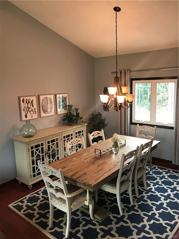 Formal dining room with new lighting, hardwoods and windows.