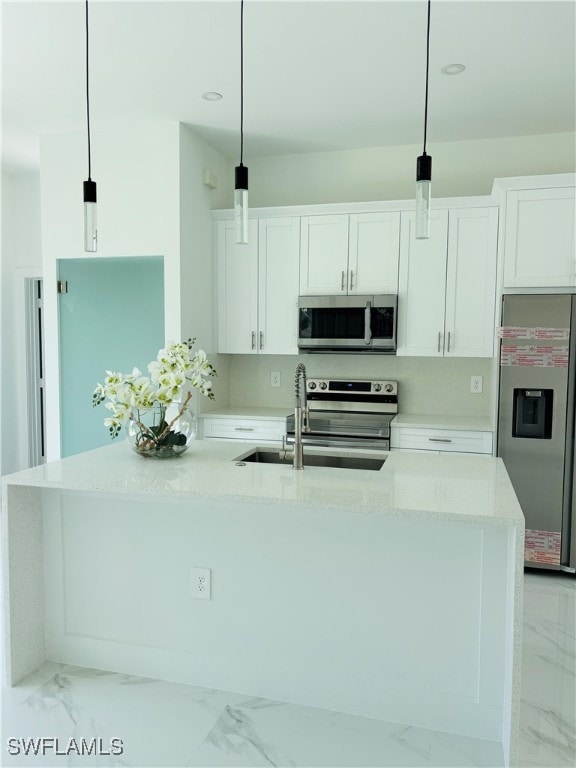 Kitchen with stainless steel appliances, light marble finish floors, white cabinetry, a center island with sink, and light stone countertops