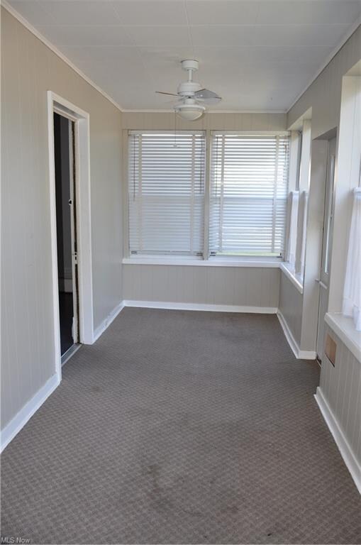 enclosed front porch with ceiling fan & lots of wi