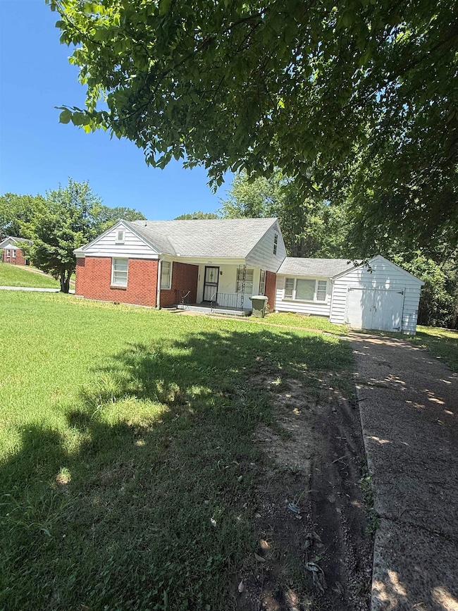 Ranch-style house with asphalt driveway, covered porch, a front lawn, a garage, and brick siding