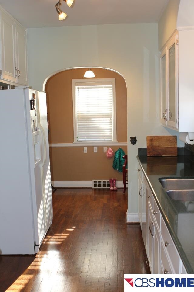 kitchen is a galley kitchen updated w/ white raised panel cabinets, granite, new tile backsplash & offers a spacious cooking area.  This view leads to the mudroom w/ access to the deck & patio.  Who doesn't want a drop zone in midtown?