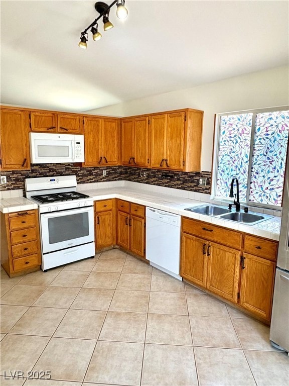 Kitchen featuring white appliances, a sink, tastef