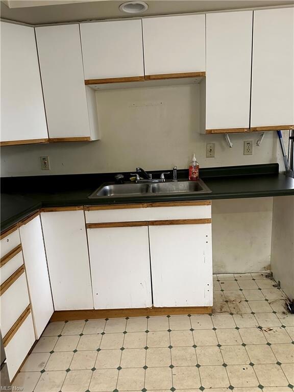 Kitchen with light tile floors, sink, countertops 