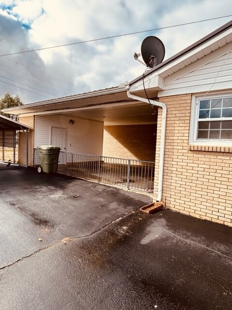 Side view of home showing 2 car attached carport.  Owners had a fence put across to keep their dog in and they used it as a covered patio, but fence can come down if you want it as carport again.