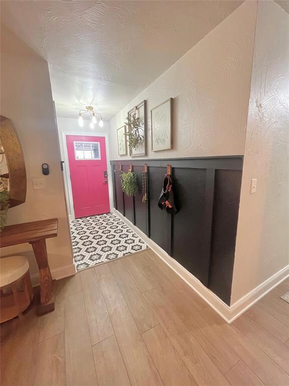 Foyer with a chandelier and light wood-type floori