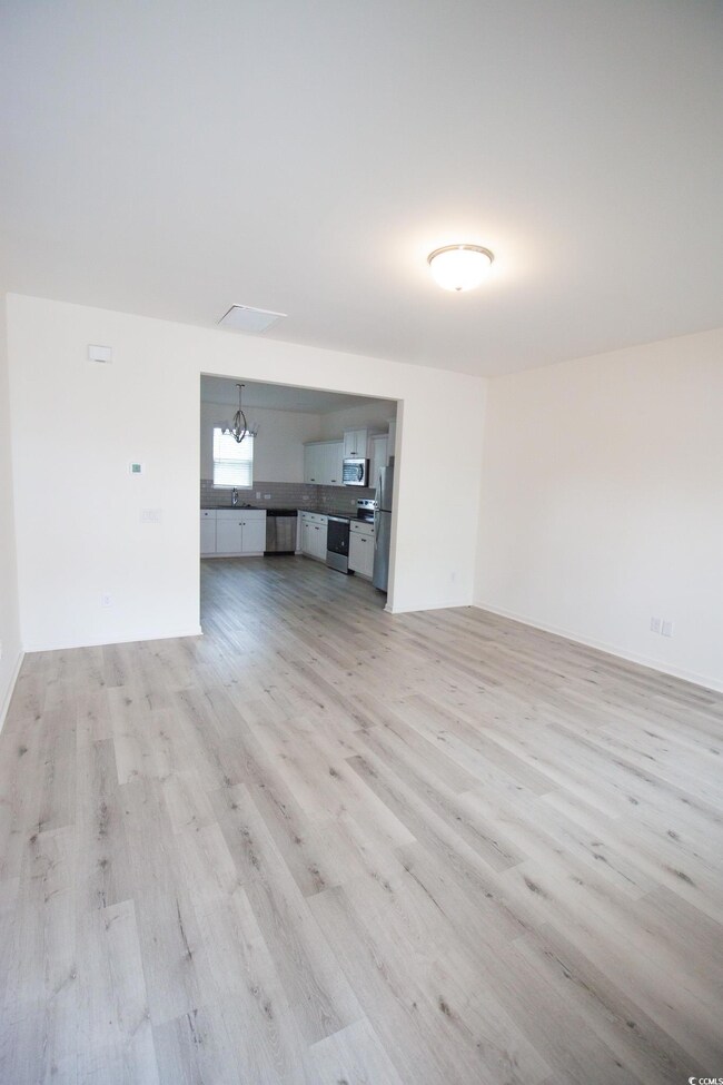 Unfurnished living room featuring light wood-type flooring and a sink