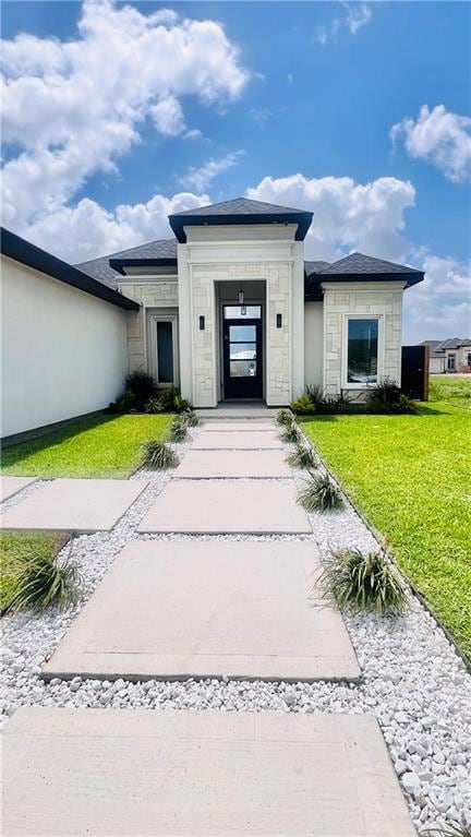 View of front of property featuring stone siding and a front yard