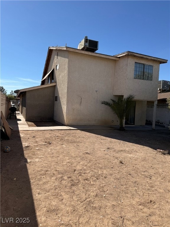 View of home's exterior with stucco siding and a cooling unit