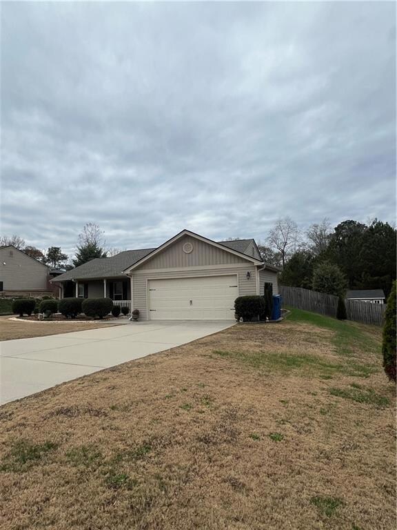 View of front of home featuring fence, a garage, b