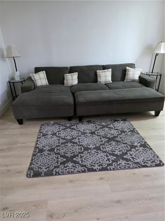Living area with baseboards and wood finished floo