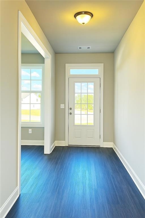 Entryway with dark wood-type flooring, baseboards,