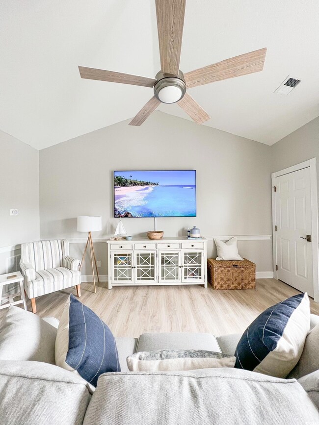 Living room featuring vaulted ceiling, light hardw