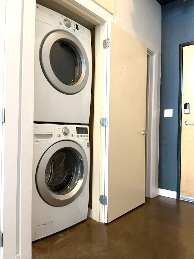 Laundry area featuring stacked washer and clothes