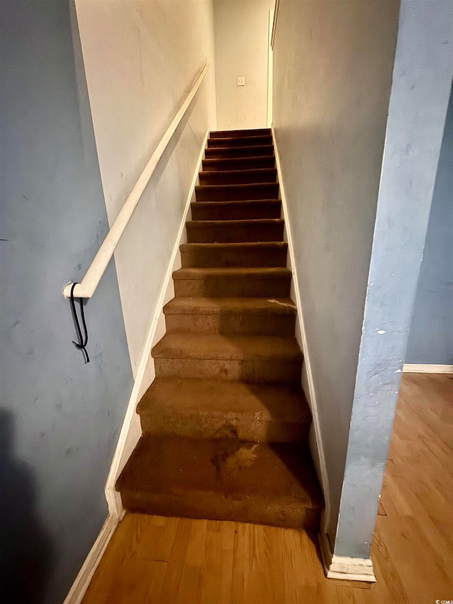 Stairway featuring baseboards and wood finished floors