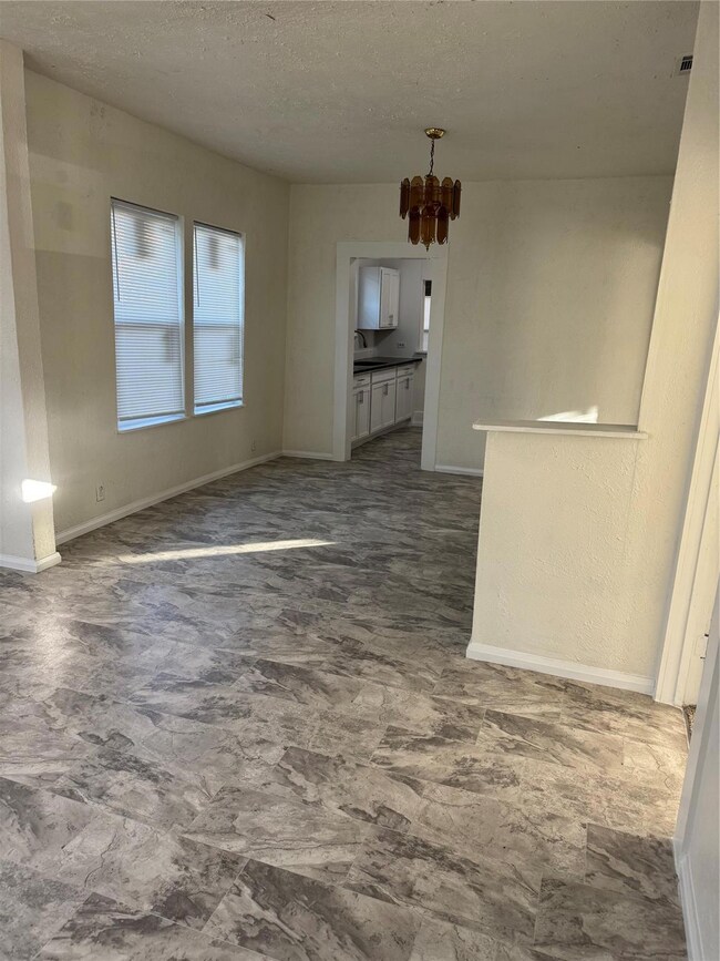 Unfurnished living room featuring sink, a textured
