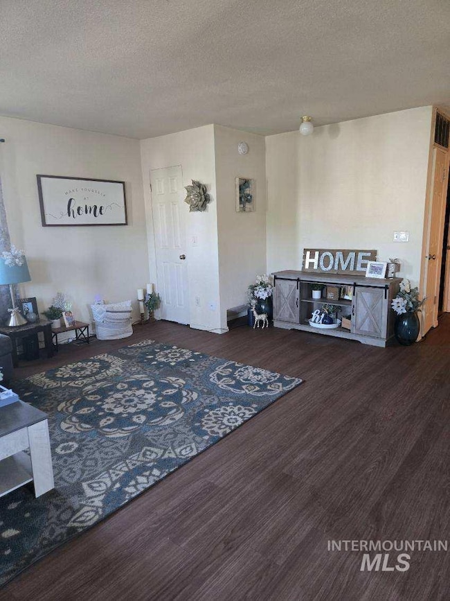 Living area with wood finished floors and a textured ceiling