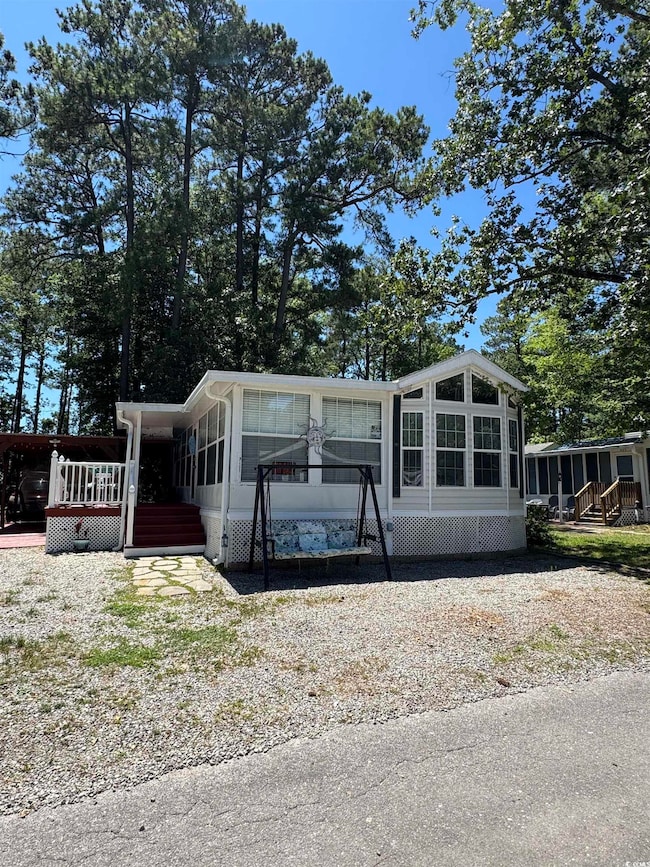 Manufactured / mobile home featuring a sunroom and a wooden deck