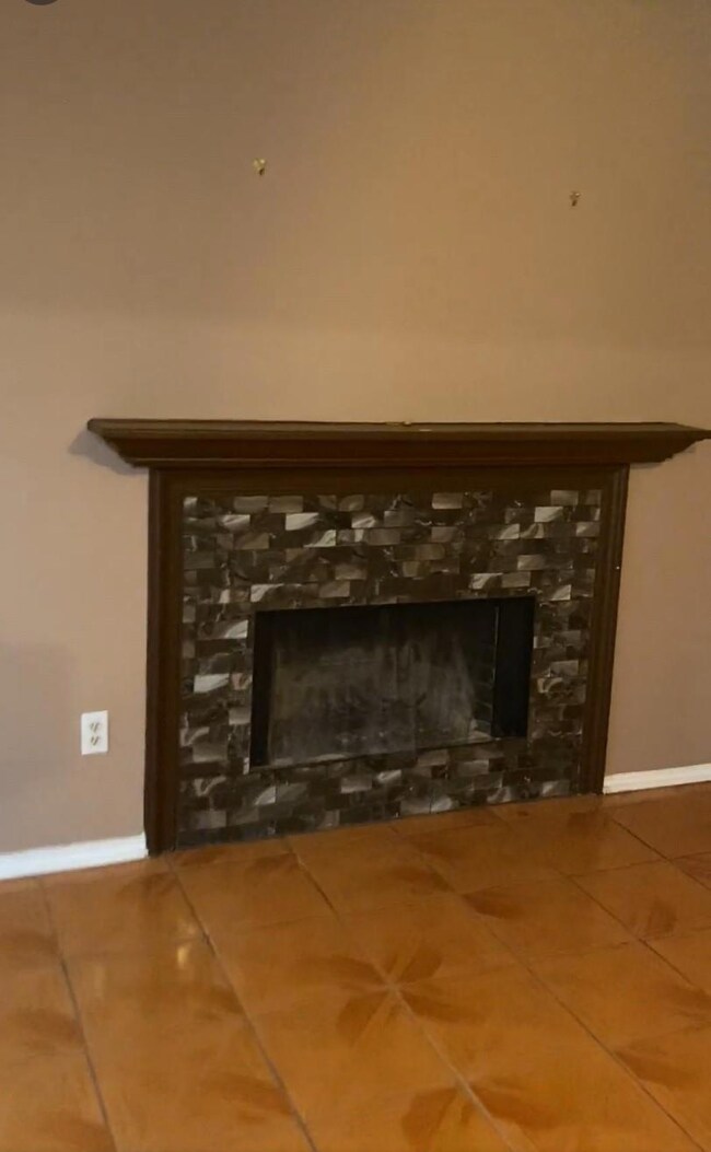 Room details featuring a fireplace and baseboards
