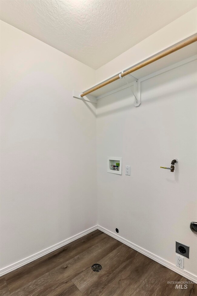 Laundry area featuring washer hookup, dark wood-style floors, hookup for an electric dryer, and a textured ceiling