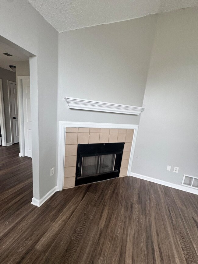Detailed view of wood finished floors, a fireplace, and baseboards