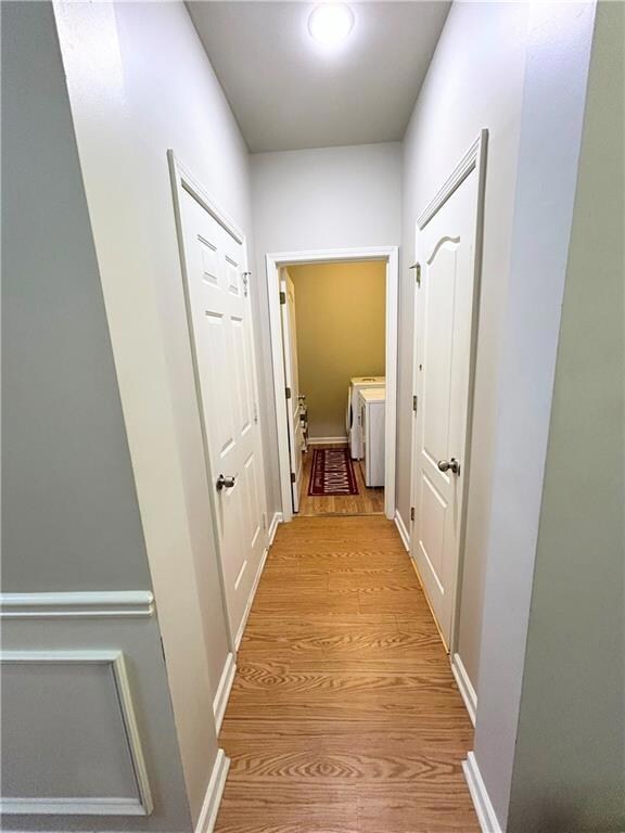 Hall featuring washer and clothes dryer and light wood-style floors