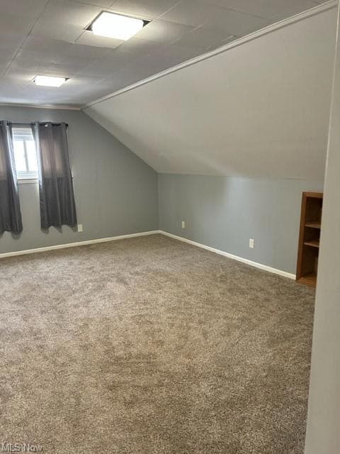 Bonus room with lofted ceiling and carpet