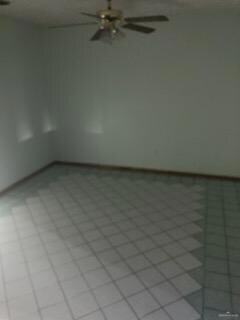 Tiled spare room featuring ceiling fan