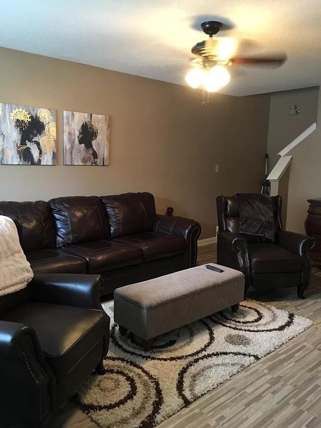 Living room with wood-type flooring and ceiling fa