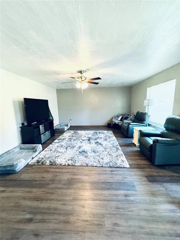Living room featuring ceiling fan, a textured ceil