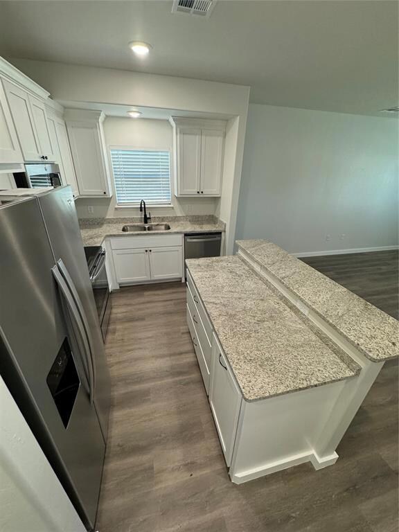 Kitchen featuring refrigerator, a sink, range, whi