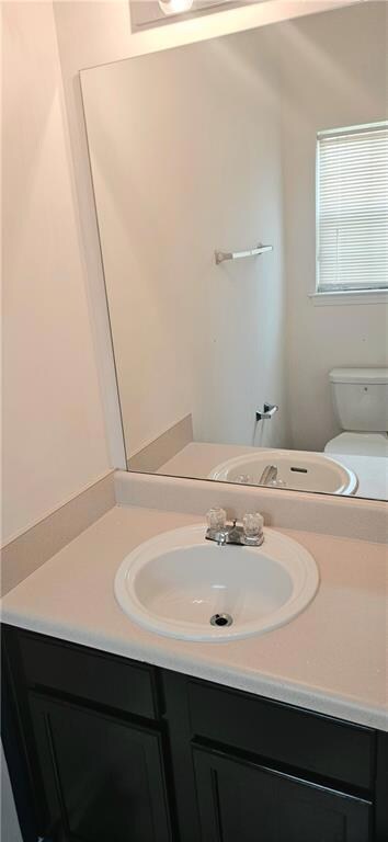 Bathroom featuring 1/2 vanity and toilet