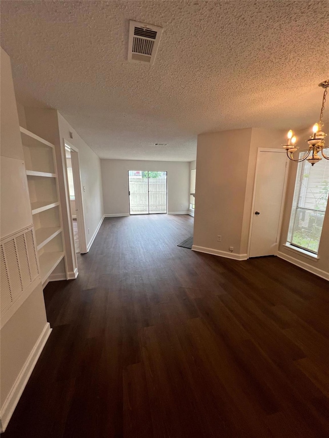 Unfurnished living room featuring a textured ceil