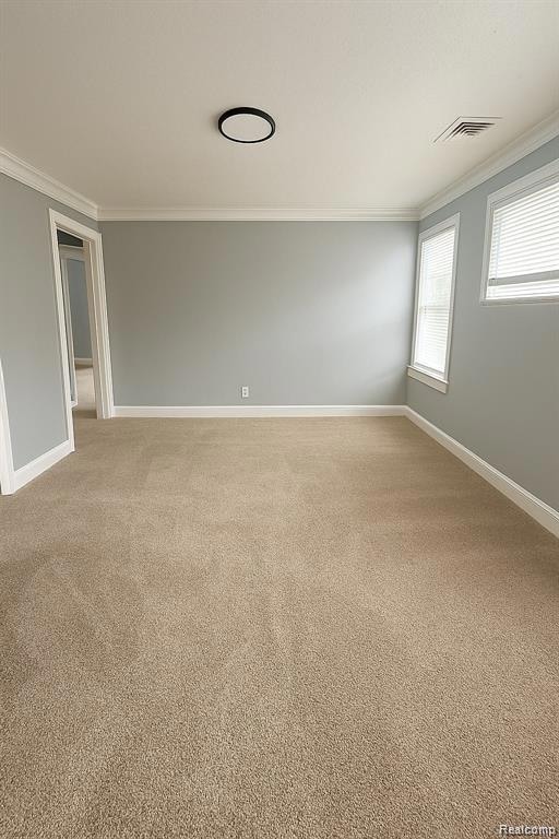 Unfurnished room with ornamental molding and light carpet