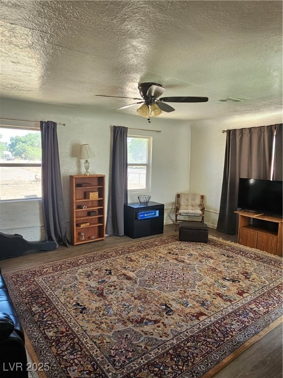 Living area with a textured ceiling, a ceiling fan