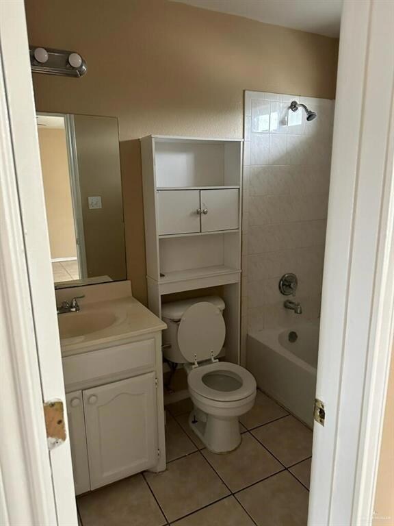 Full bathroom with tile patterned flooring, vanity, toilet, and tiled shower / bath