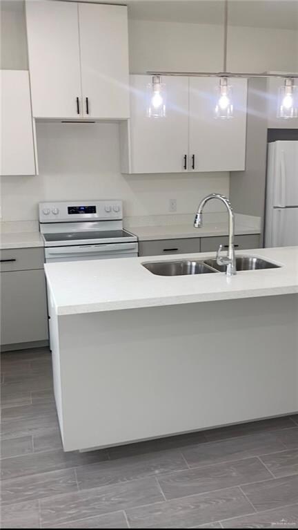 Kitchen featuring white appliances, white cabinets, light countertops, and modern cabinets
