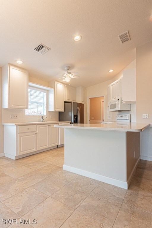 Kitchen with, a ceiling fan, stainless steel refri