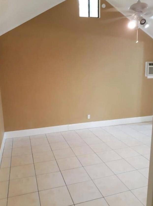 Empty room featuring a ceiling fan, baseboards, a