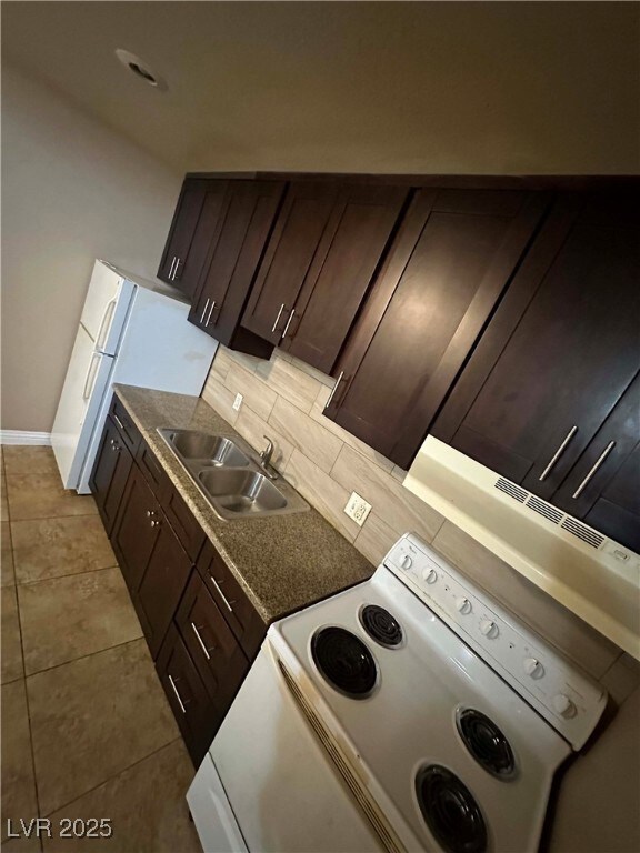 Kitchen featuring white stove, a sink, decorative