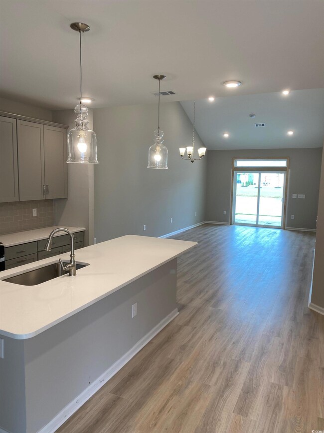 Kitchen with light wood-type flooring, backsplash,