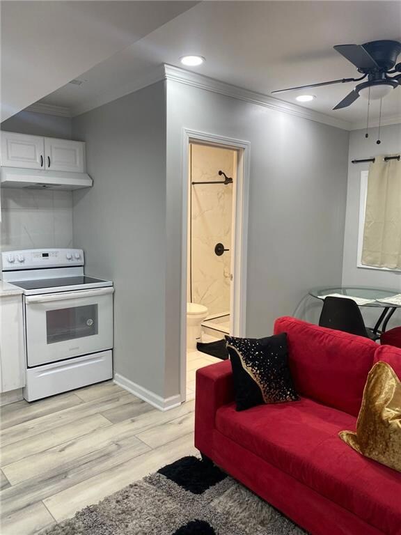 Living area with crown molding, light wood finished floors, ceiling fan, recessed lighting, and baseboards