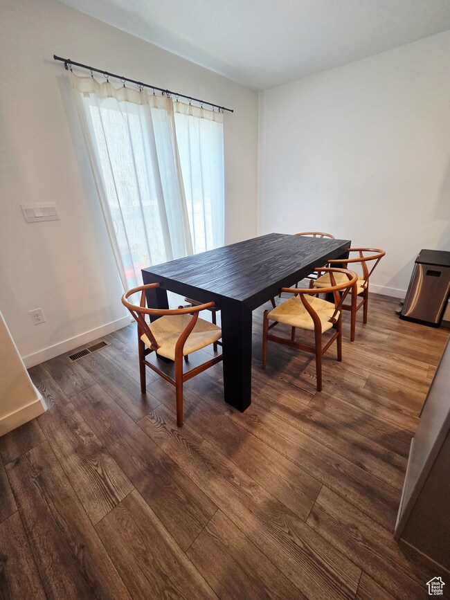 Dining room with dark laminate flooring and baseboards