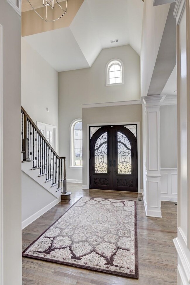Another angle showing the 2 story foyer and iron entry door. Notice the custom crafted trim details.