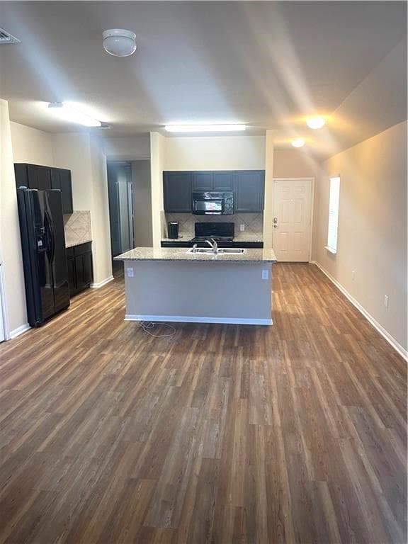 Kitchen featuring black appliances, dark wood-sty