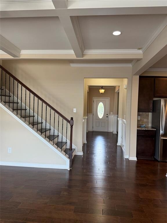 Foyer featuring stairway, ornamental molding, dark wood-style flooring, baseboards, and beamed ceiling