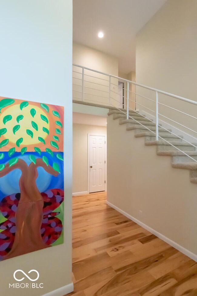 stairs with wood finished floors and recessed lighting