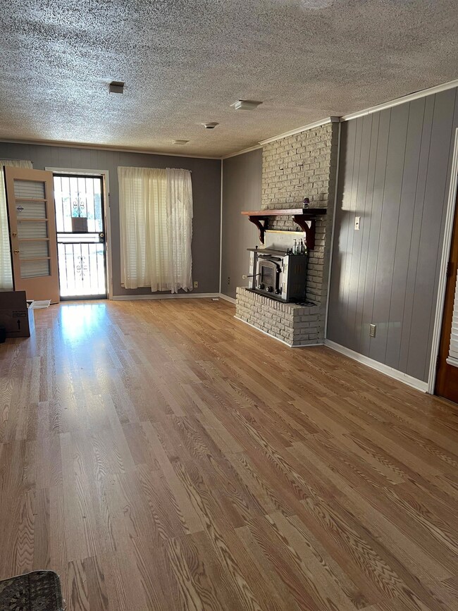 Unfurnished living room featuring a textured ceili