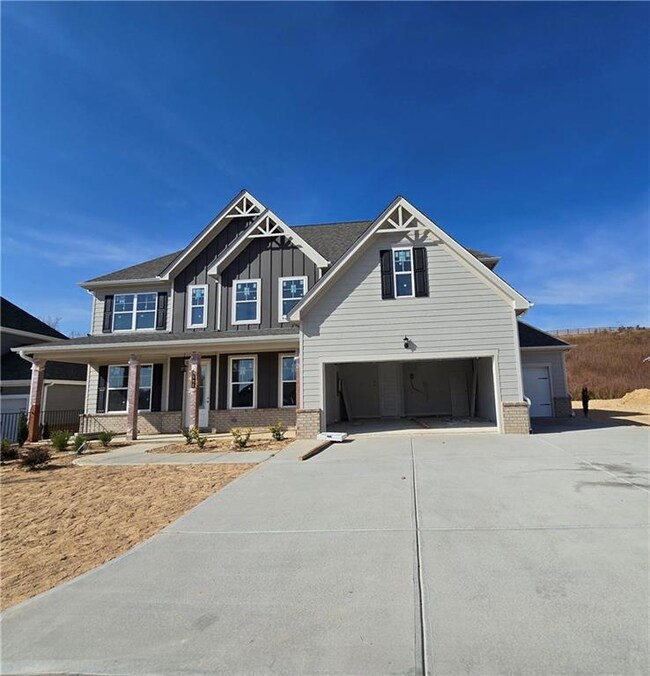 Craftsman house featuring board and batten siding, brick siding, driveway, a porch, and a garage