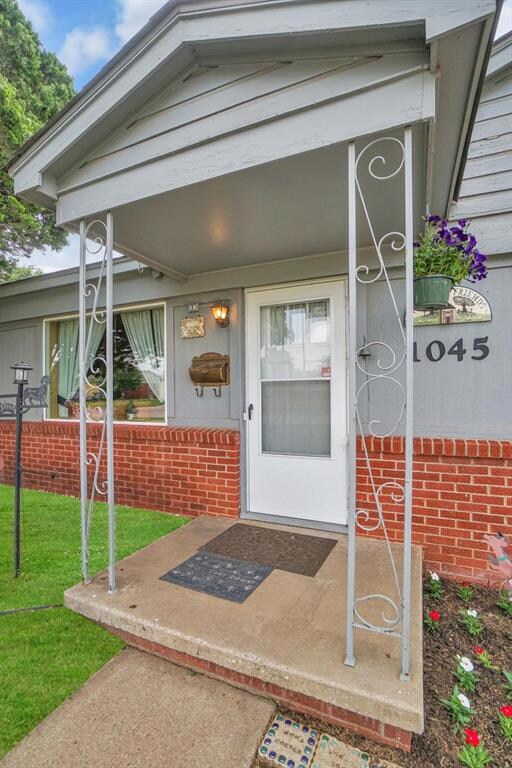 View of exterior entry with a lawn