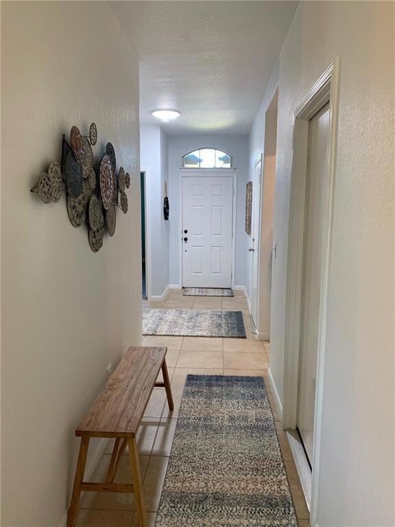 Doorway with light tile patterned flooring and ba